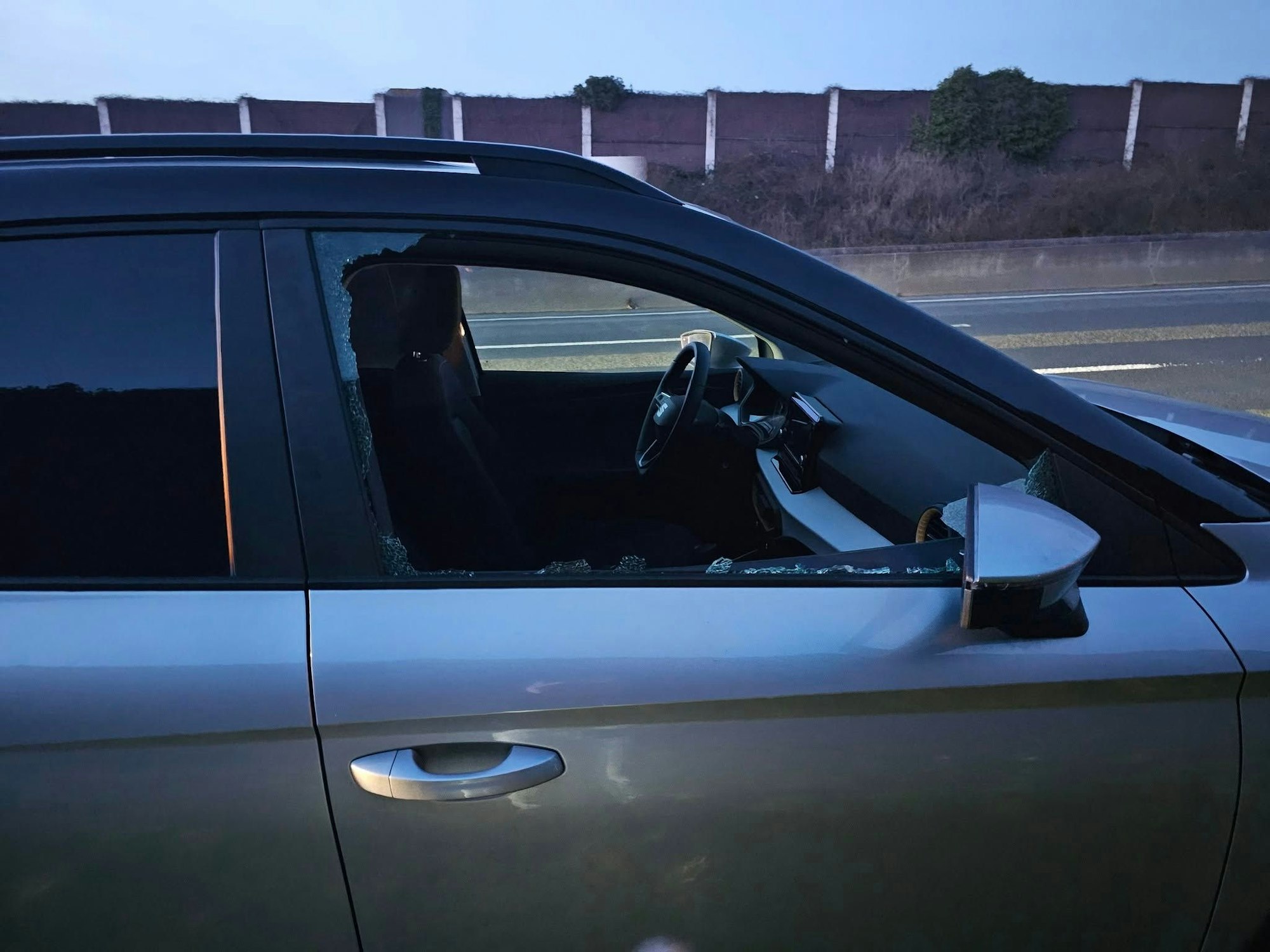 Das Beifahrerfenster eines Autos ist zersplittert.