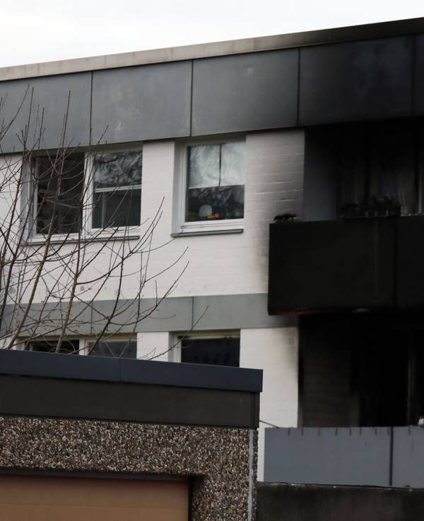 Über und unter einem Balkon eines Mehrfamilienhauses ist schwarz vor Ruß.