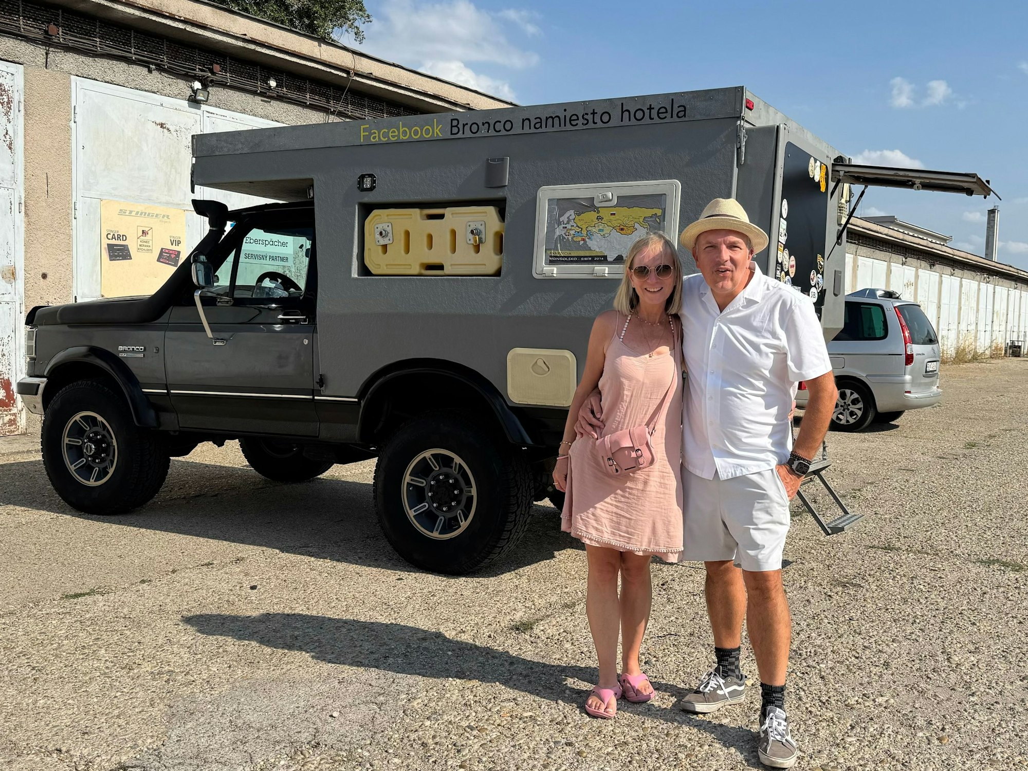 Ein Mann und eine Frau stehen vor einem umgebauten Ford.