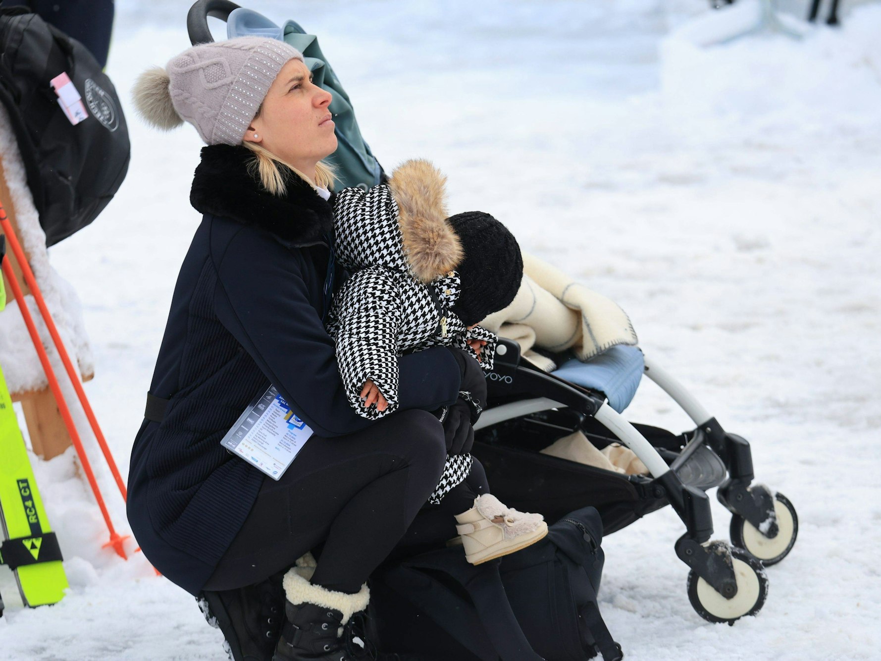 Alexis Pinturaults Ehefrau Romane verfolgt mit Kind auf dem Arm ein Rennen.