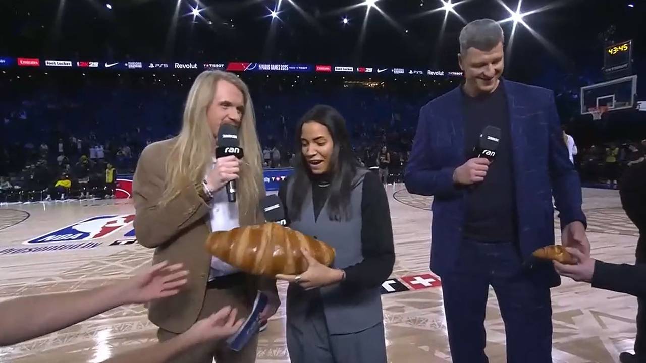 Die neben Icke Dommisch stehende TV-Expertin Ireti Amojo bekommt ein Riesen-Croissant überreicht.