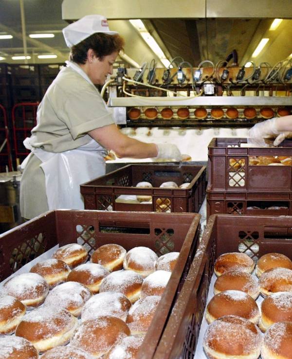 Zwei Arbeiterinnen packen am Donnerstag (19.02.2004) in der Glockenbrot-Bäckerei in Frankfurt frisch gebackene Kreppel,