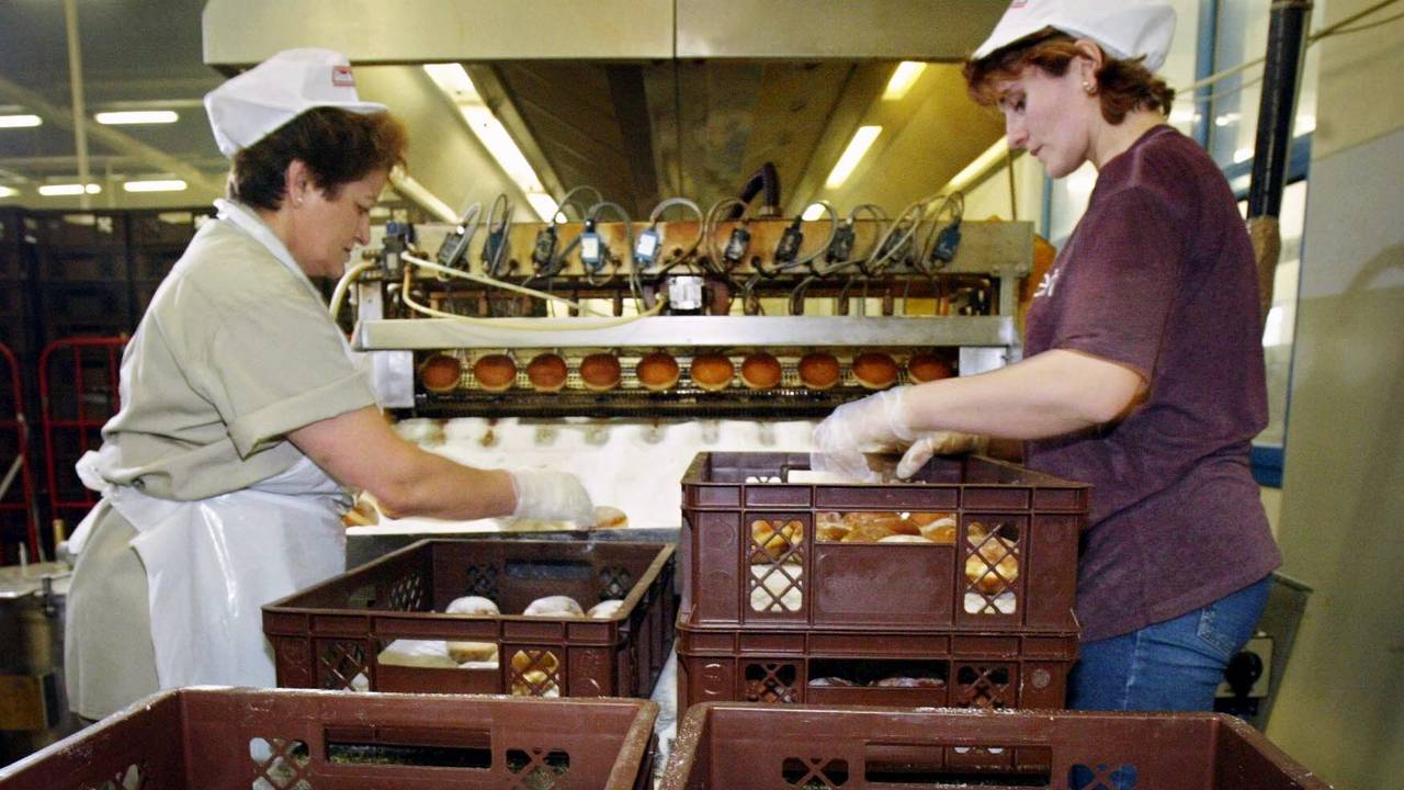 Zwei Arbeiterinnen packen am Donnerstag (19.02.2004) in der Glockenbrot-Bäckerei in Frankfurt frisch gebackene Kreppel,