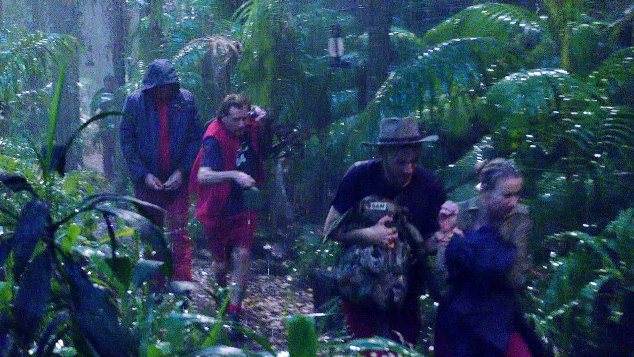 Anna-Carina Woitschack (r.), Sam Dylan (M.) und Jörg Dahlmann eilen ins Dschungeltelefon, um sich vor Starkregen und Blitzen zu schützen.
