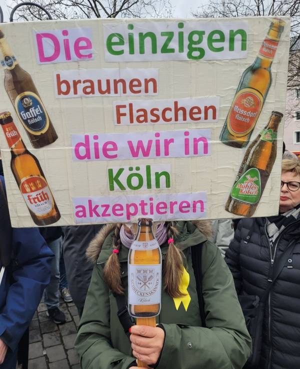 „Die einzigen braunen Flaschen, die wir in Köln akzeptieren“, steht bei der Demo gegen Rechts auf dem Plakat.