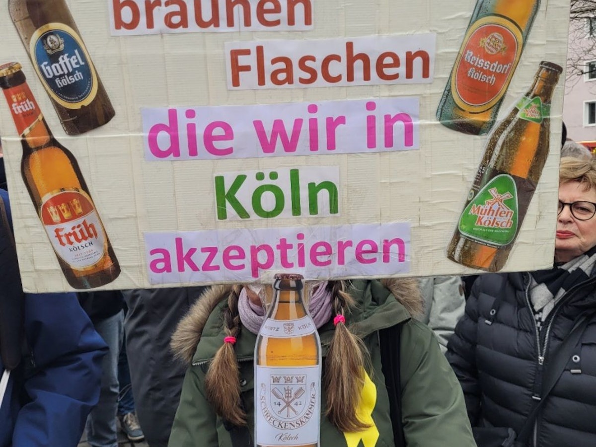 „Die einzigen braunen Flaschen, die wir in Köln akzeptieren“, steht bei der Demo gegen Rechts auf dem Plakat.