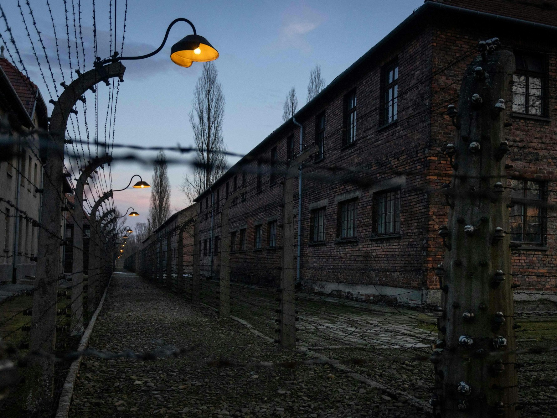 Stacheldrahtzaun und Baracken des ehemaligen deutschen NS-Konzentrations- und Vernichtungslagers Auschwitz-Birkenau, heute Gedenkstätte und Museum.