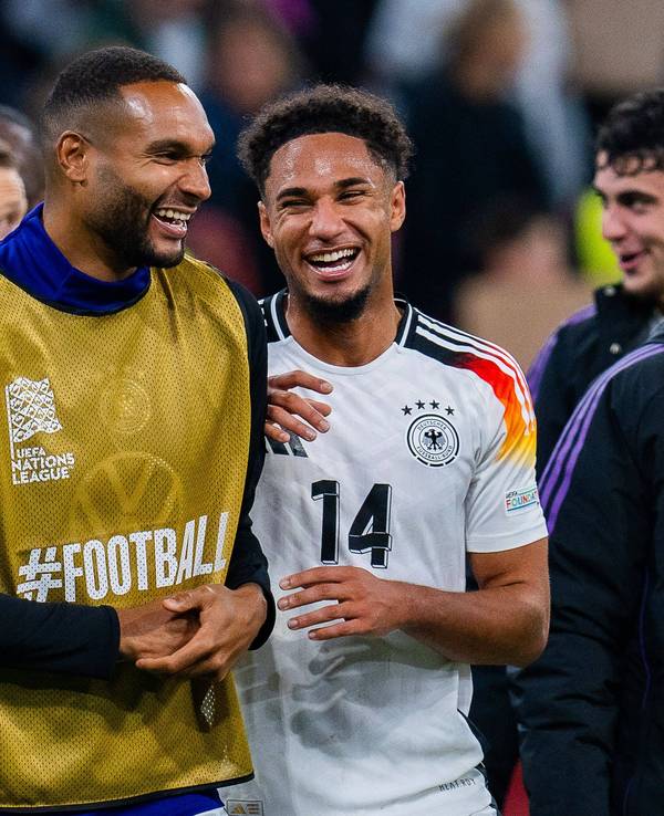 Kevin Schade und Jonathan Tah lachen nach einem Länderspiel zusammen.