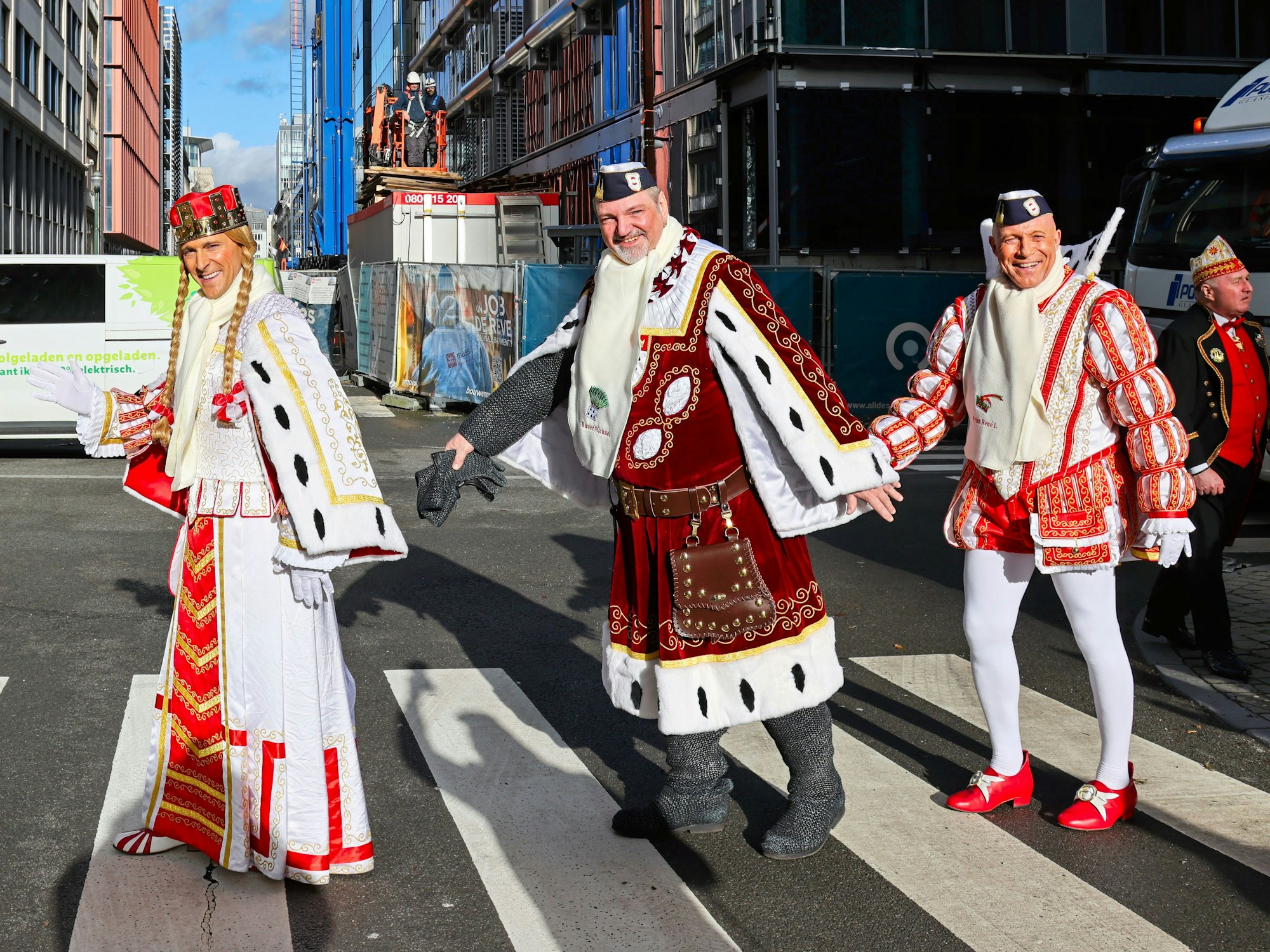Das Kölner Dreigestirn geht über einen Zebrastreifen.
