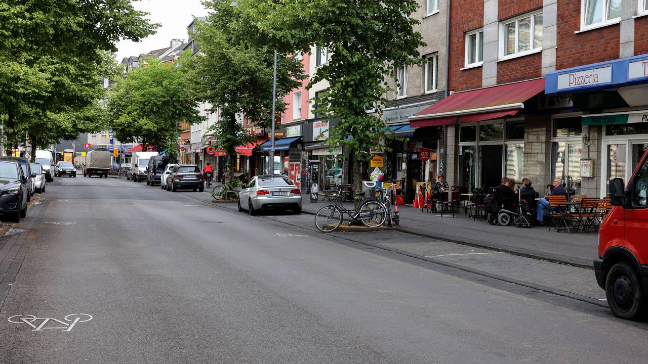 Autos auf der Venloer Straße in Köln, an den Straßenrändern sind Cafés und andere Außengastro zu sehen.