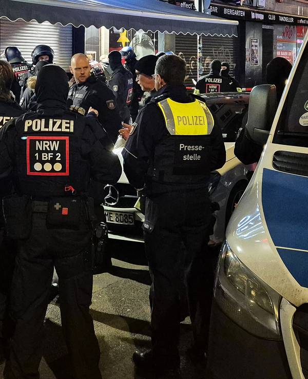 Einsatzkräfte der Polizei stehen vor einer Shisha-Bar.