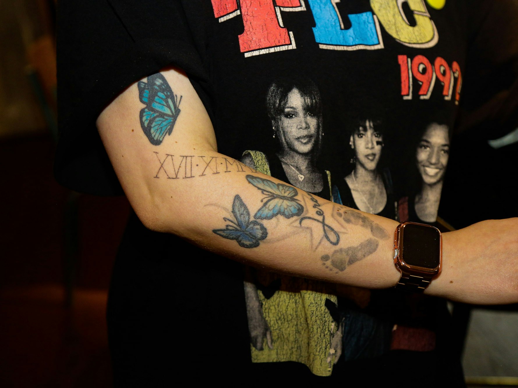 Tattoo einer Mitarbeiterin des Ruby Hotels in Köln. Ihr Arm ist mit Buchstaben und Schmetterlingen verziert.