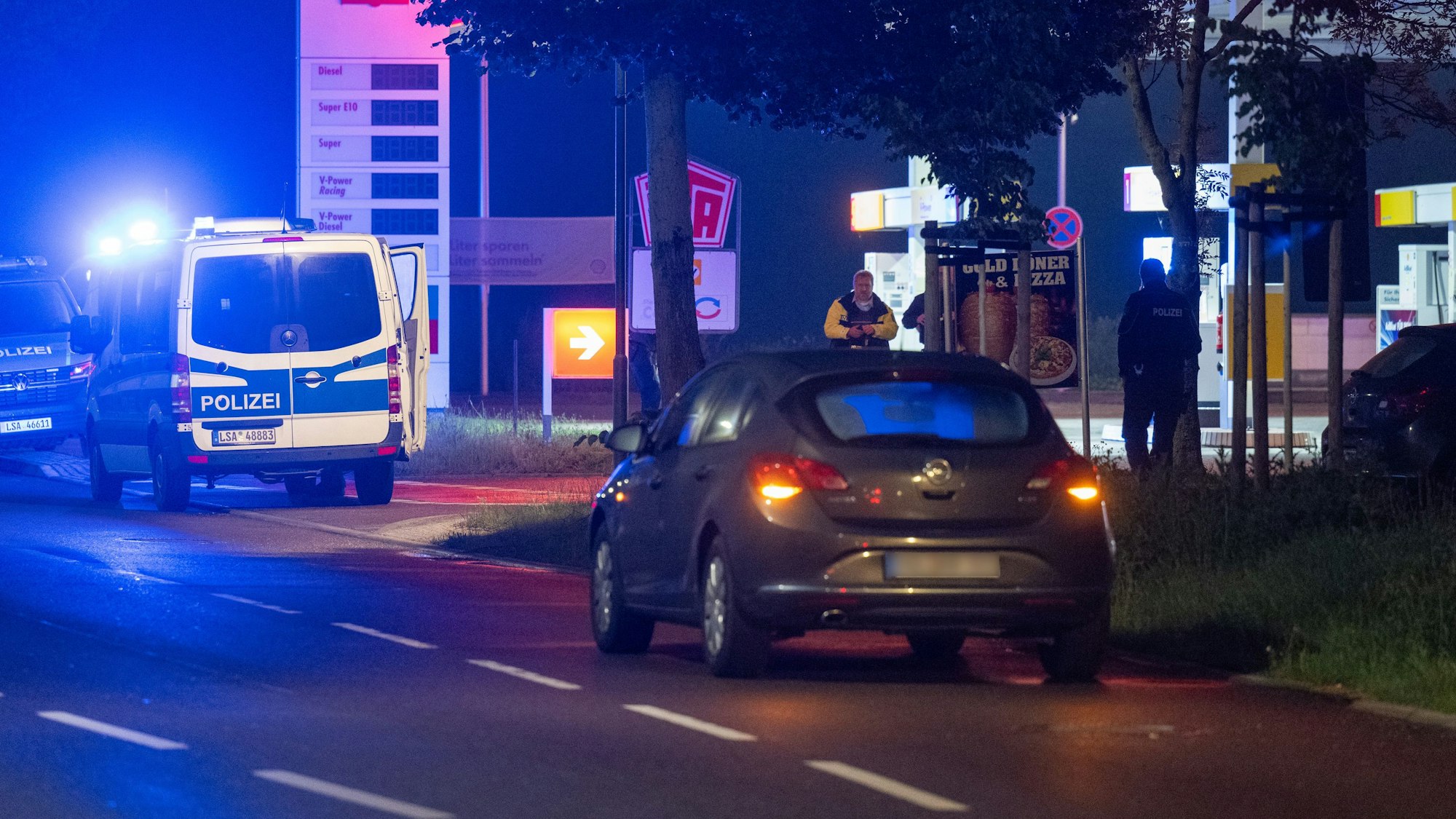 Die Polizei sichert Spuren an einem Tatort an einer Tankstelle.