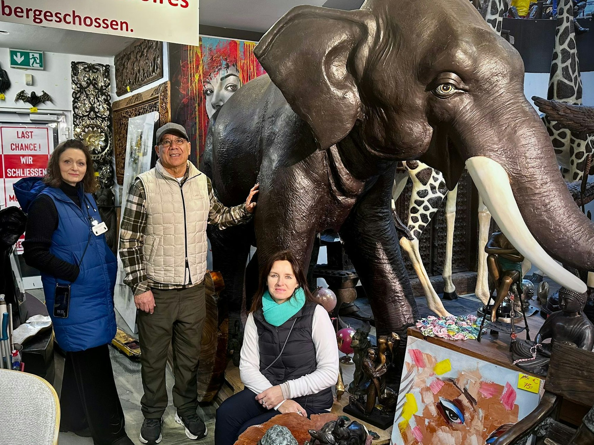 Das Betreiber-Paar Paola Rotondi (l.) und Mohammed Hiatullah sowie Mitarbeiterin Snieguole Baksyte stehen neben dem Markenzeichen des Geschäfts, dem Schwarzen Elefanten.
