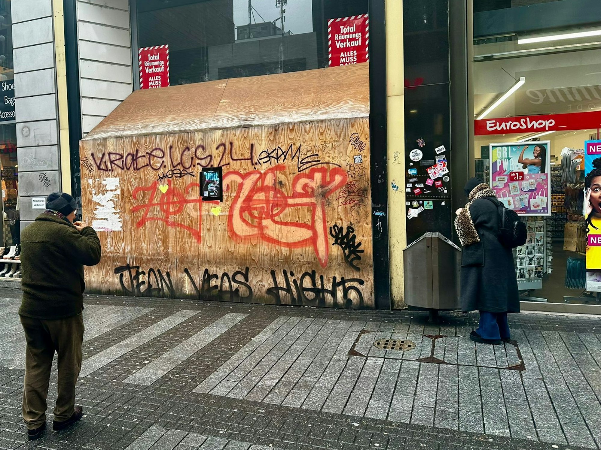 Ein Euroshop befindet sich neben einem leeren Ladenlokal, dessen Eingang mit vollgesprayten Brettern verbarrikadiert wurde.