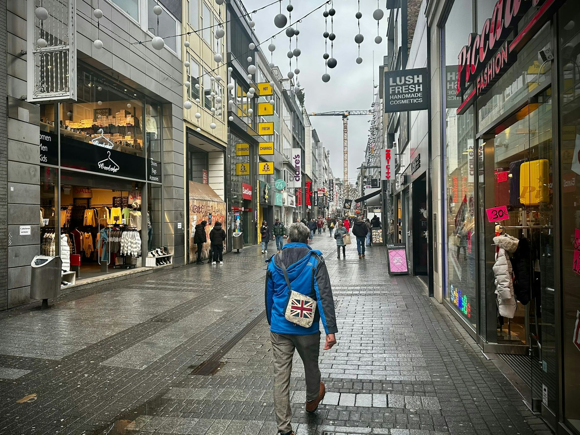 Menschen laufen über die Hohe Straße.
