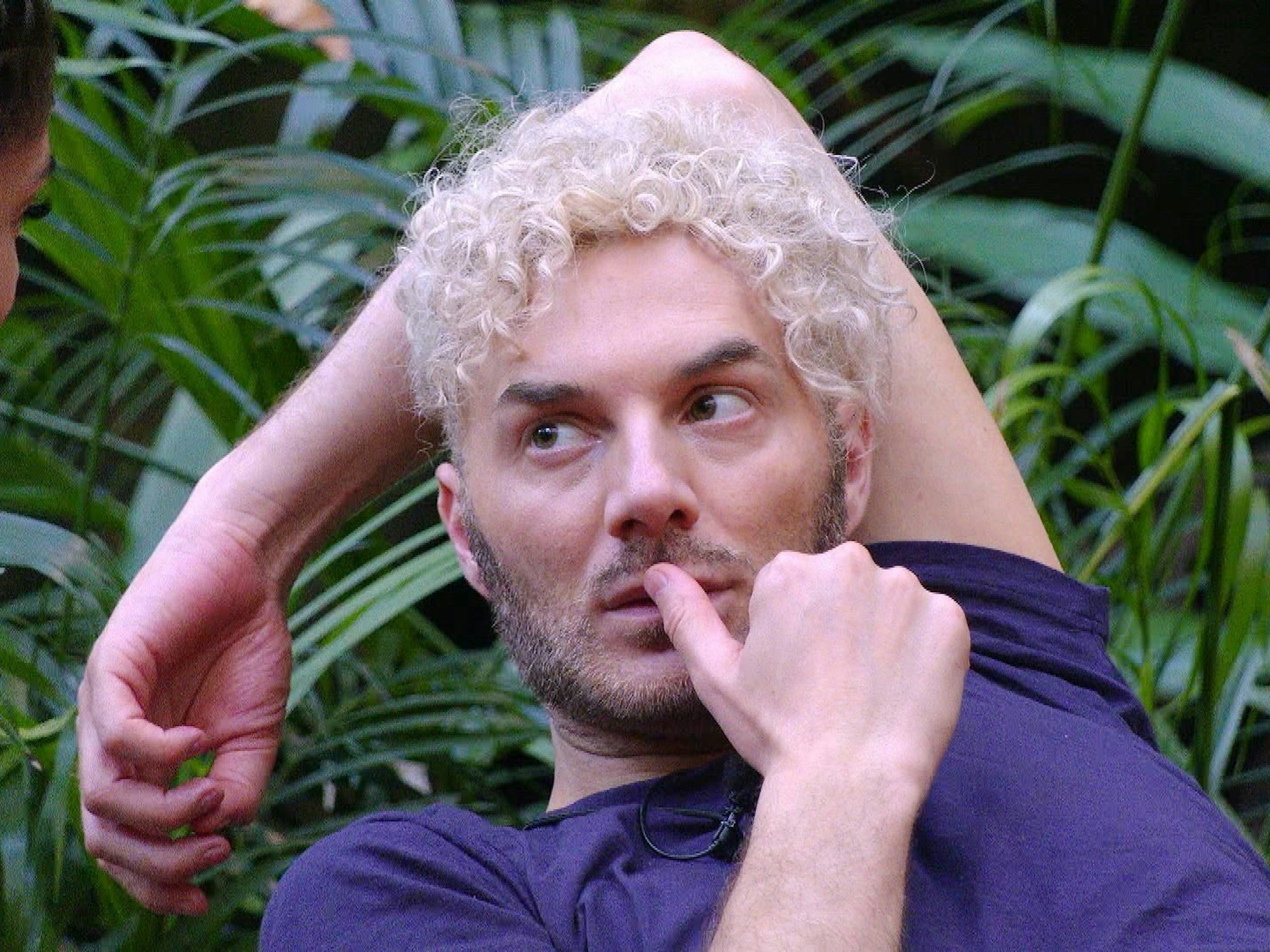 Sam Dylan schaut im Dschungelcamp zur Seite.