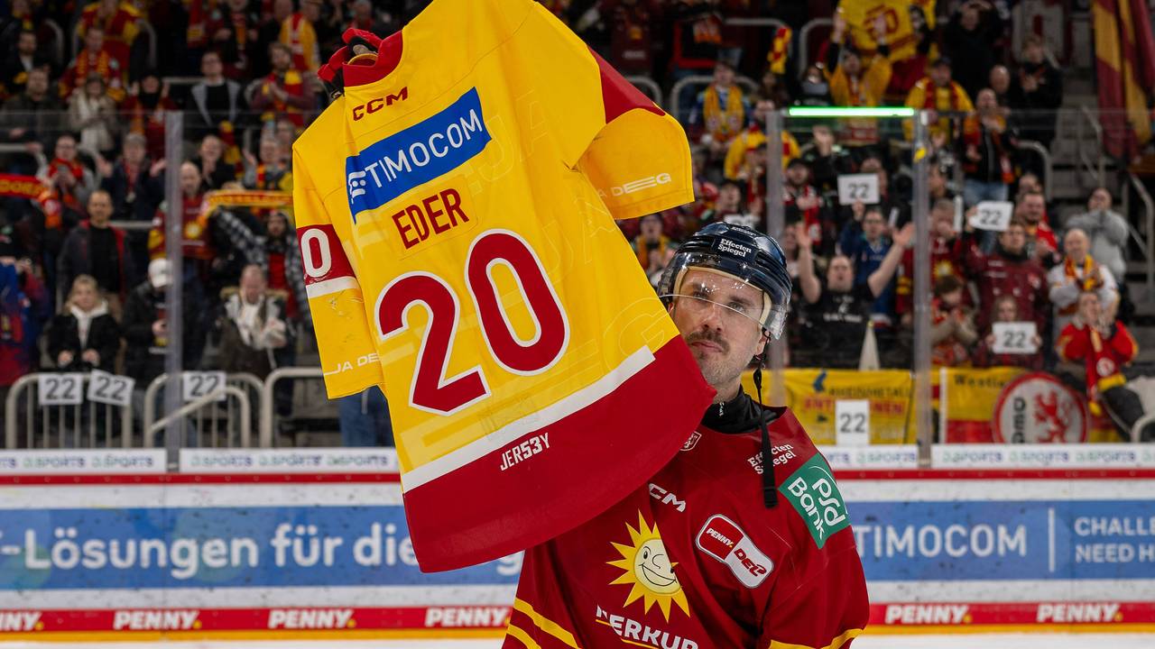 DEG-Profi Brendan O'Donnell hält ein DEG-Trikot des verstorbenen Tobias Eder mit der Nummer 20 hoch.
