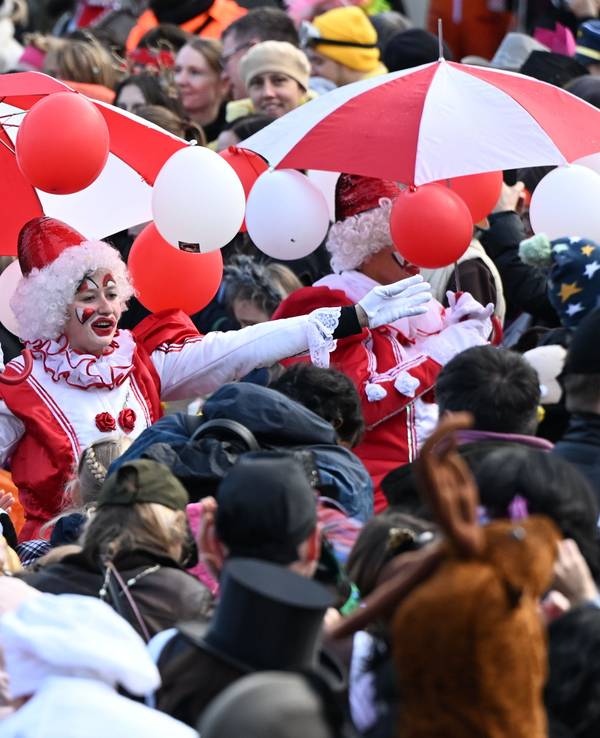 Karnevalisten ziehen beim Rosenmontagszug durch die feiernde Menschenmenge. Am Rosenmontag erreicht der Straßenkarneval seinen Höhepunkt. Was viele nicht wissen: der Zeitpunkt richtet sich nach Ostern und dem Vollmond.