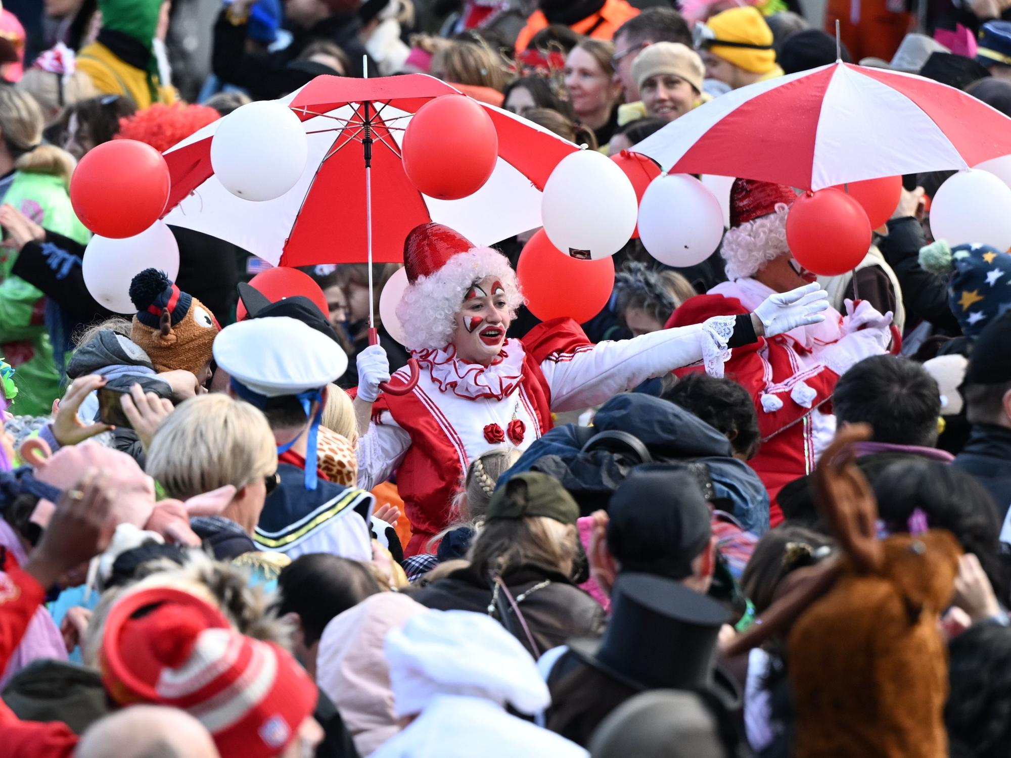 Karnevalisten ziehen beim Rosenmontagszug durch die feiernde Menschenmenge. Am Rosenmontag erreicht der Straßenkarneval seinen Höhepunkt. Was viele nicht wissen: der Zeitpunkt richtet sich nach Ostern und dem Vollmond.