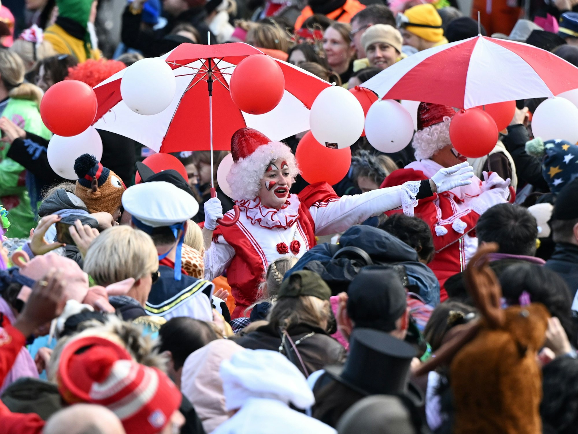 Karnevalisten ziehen beim Rosenmontagszug durch die feiernde Menschenmenge. Am Rosenmontag erreicht der Straßenkarneval seinen Höhepunkt. Was viele nicht wissen: der Zeitpunkt richtet sich nach Ostern und dem Vollmond.