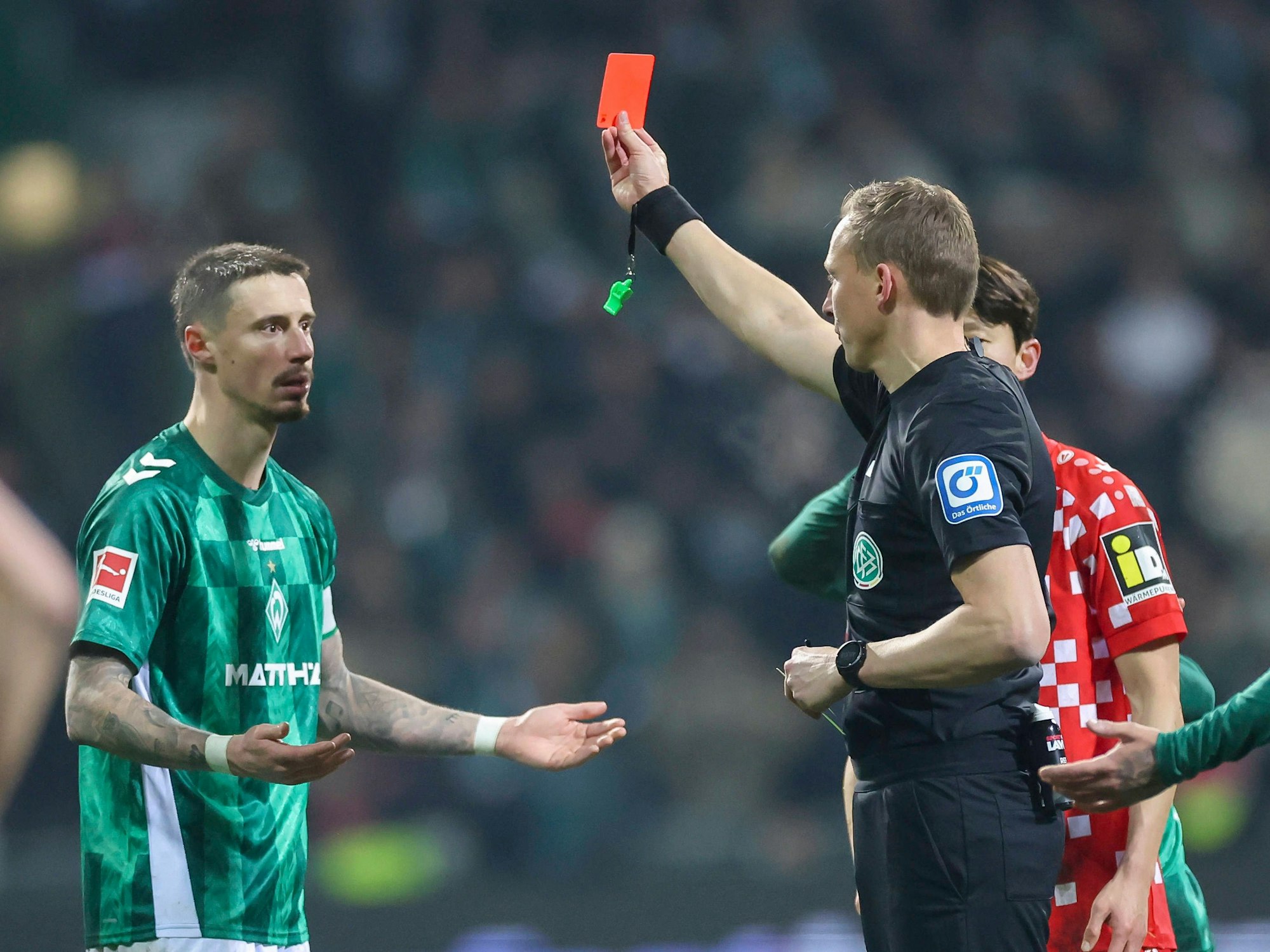 Schiedsrichter Martin Petersen (rechts) zeigt dem Bremer Marco Friedl am 31. Januar 2025 die Gelb-Rote Karte.