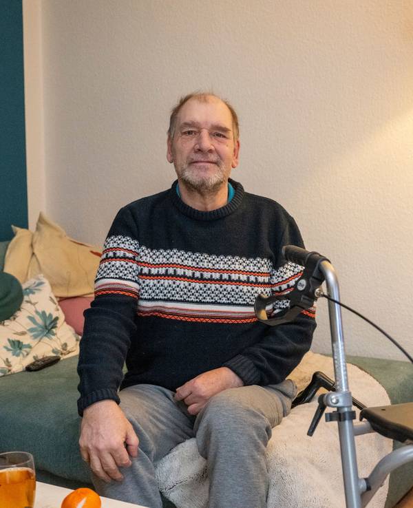 Ein Mann sitzt auf einem Sofa.