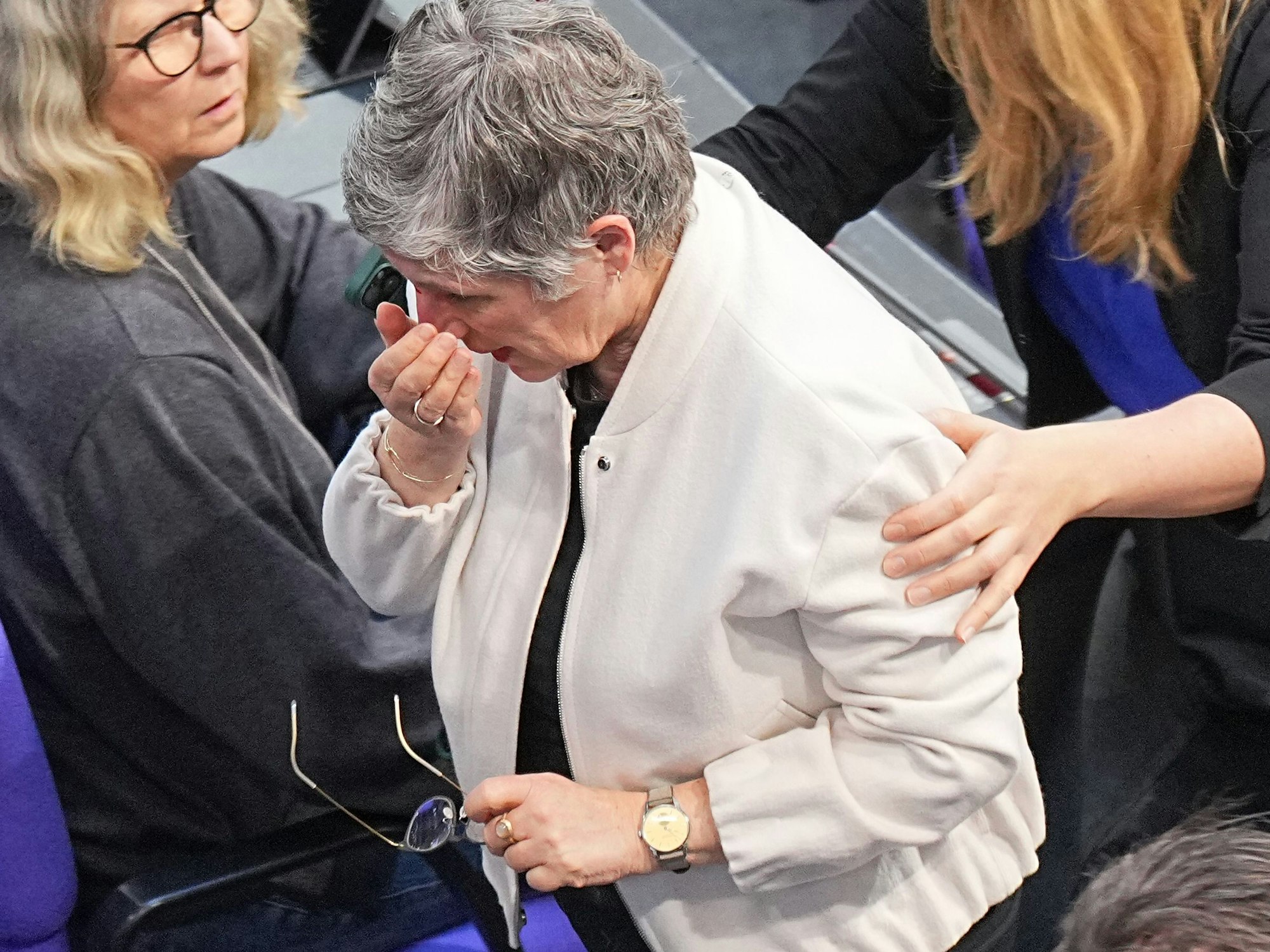 Britta Haßelmann (Mitte), Bundestagsfraktionsvorsitzende von den Grünen, wird nach einem Sturz aus dem Plenarsaal im Bundestag begleitet.