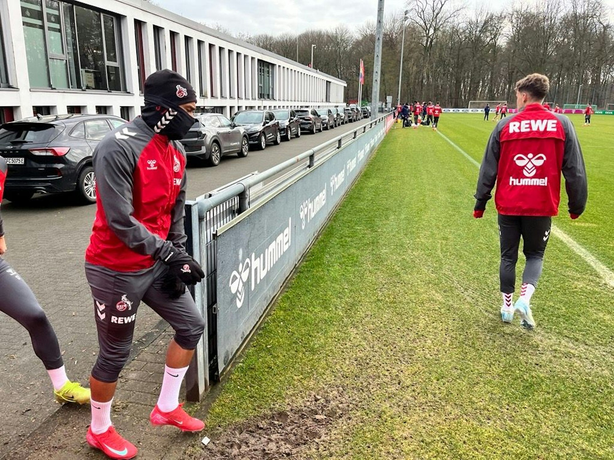 Linton Maina geht mit Mütze und Schal auf den Trainingsplatz.