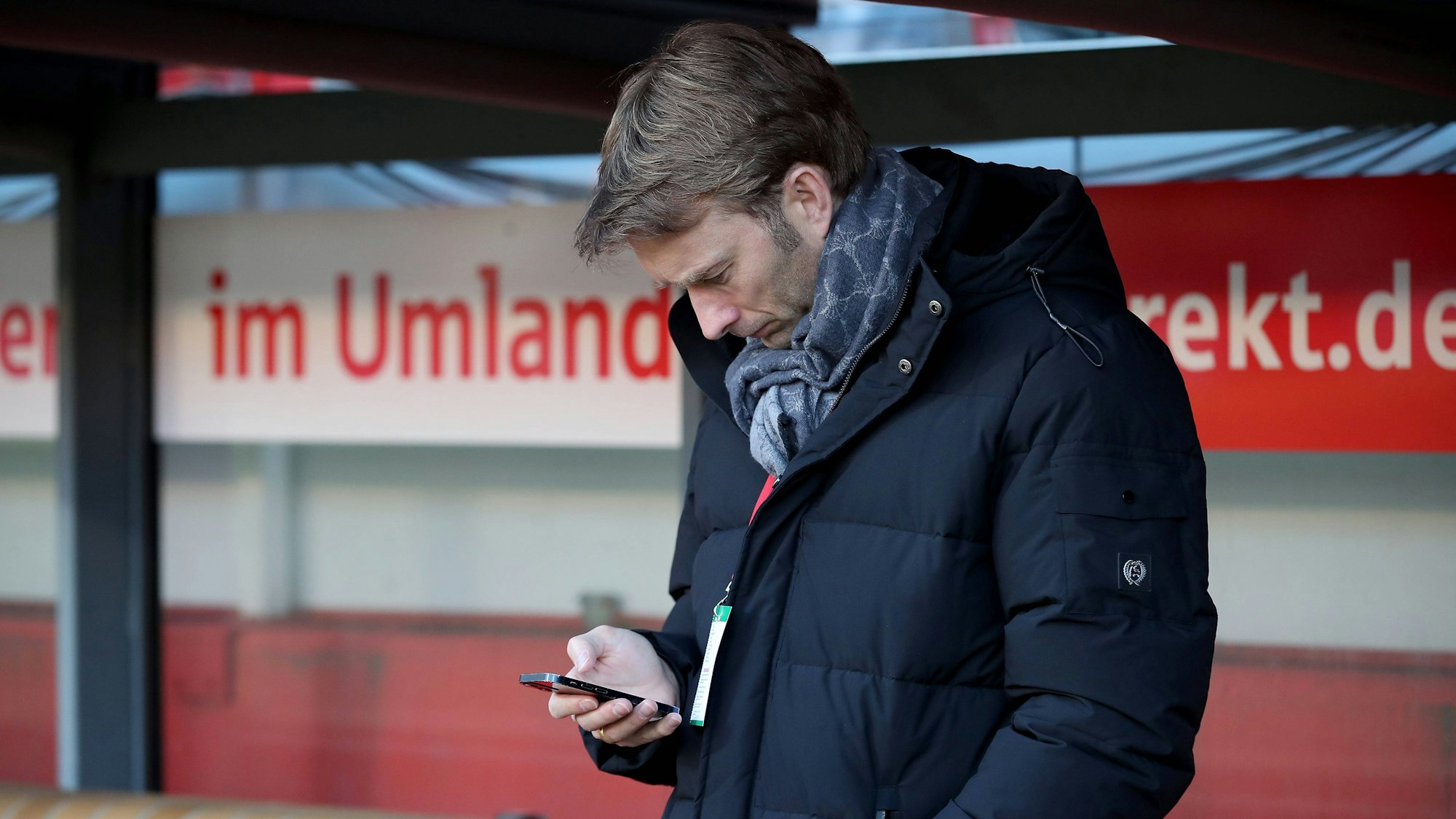 Simon Rolfes schaut auf sein Handy.