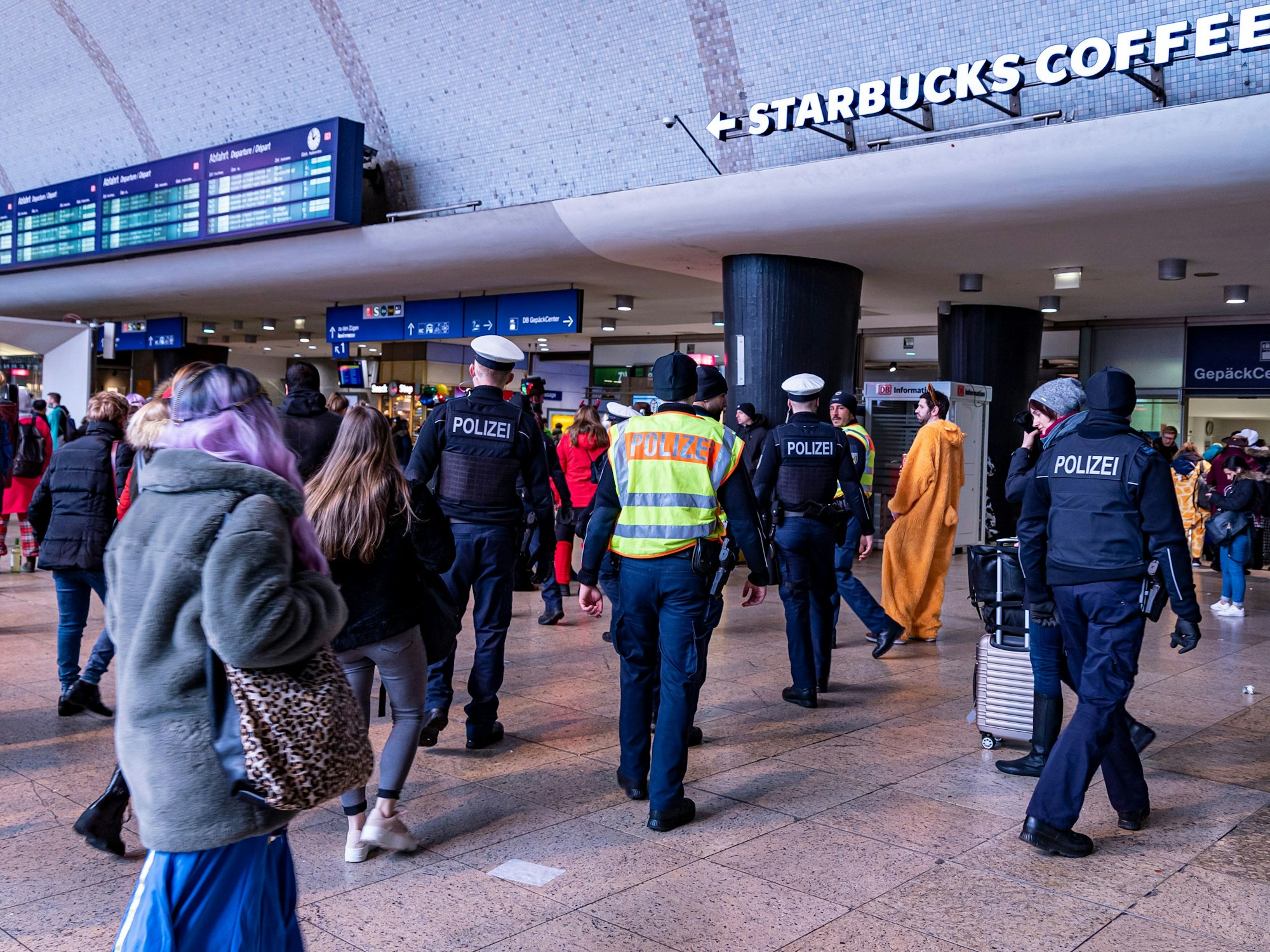 Polizei geht mit mehreren Einsatzkräften durch den Hauptbahnhof in Köln.