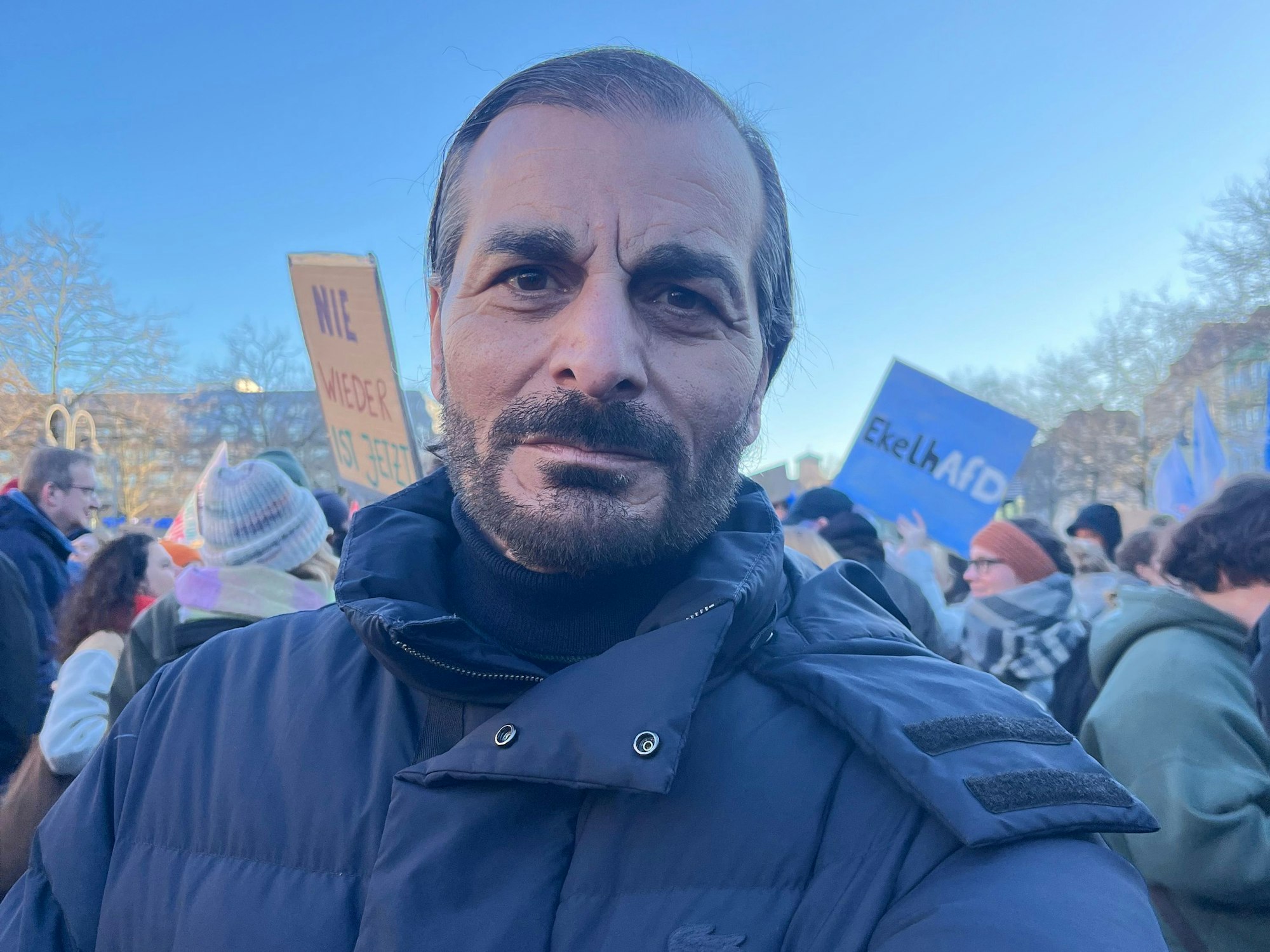 Ein Mann macht auf einer Demo ein Selfie von sich.