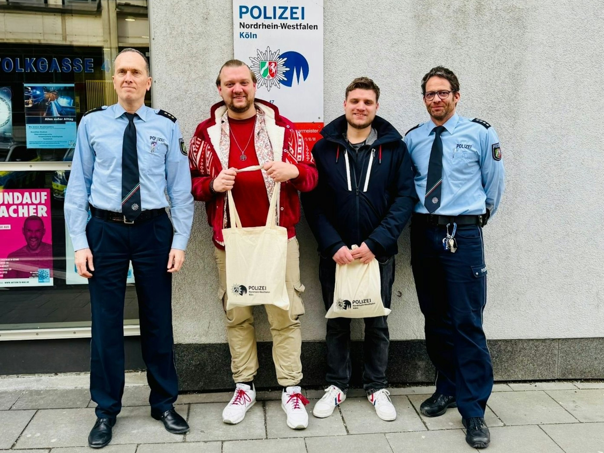 Zwei Polizisten überreichen dem Lupo-Musiker und dessen Bruder Beutel mit Geschenken.