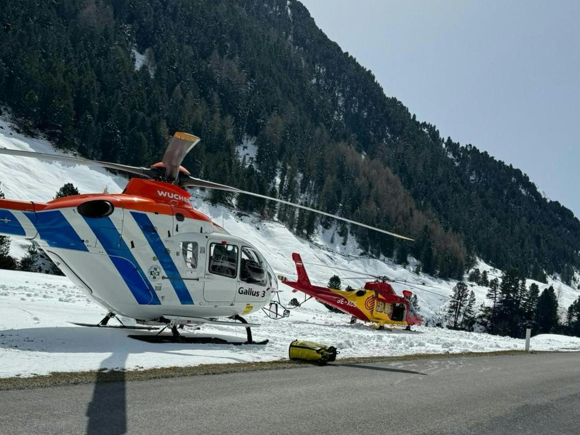 Rettungshubschrauber stehen nach einem Lawinenabgang an einer Straße in Vent.