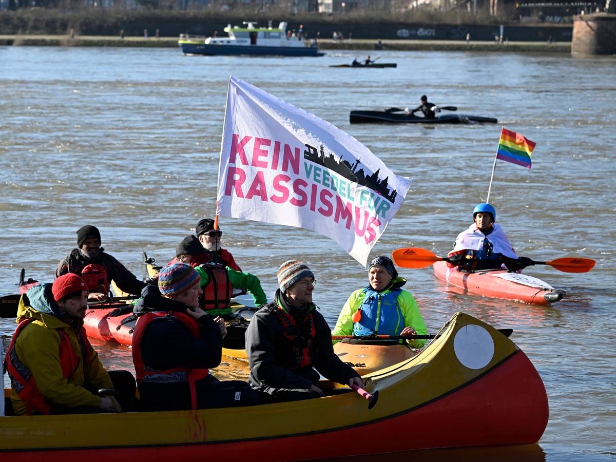 Auf einem Kanu weht eine Fahne mit der Aufschrift „Kein Veedel für Rassismus“.