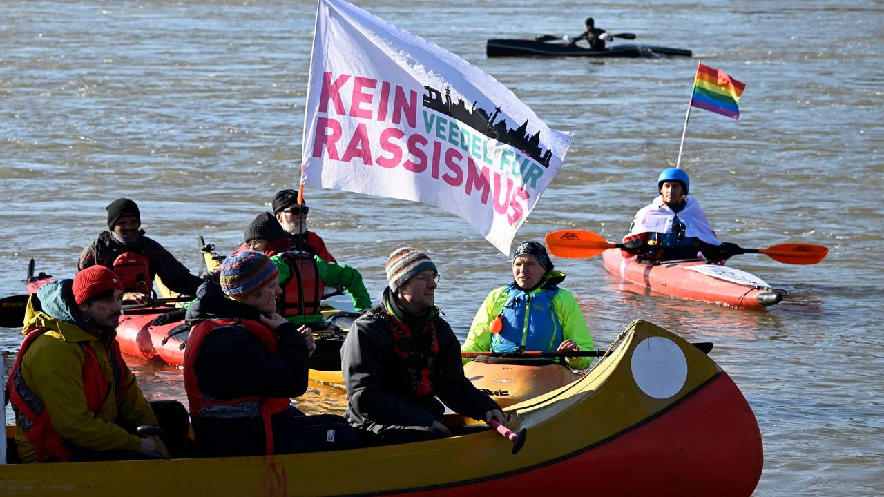 Auf einem Kanu weht eine Fahne mit der Aufschrift „Kein Veedel für Rassismus“.