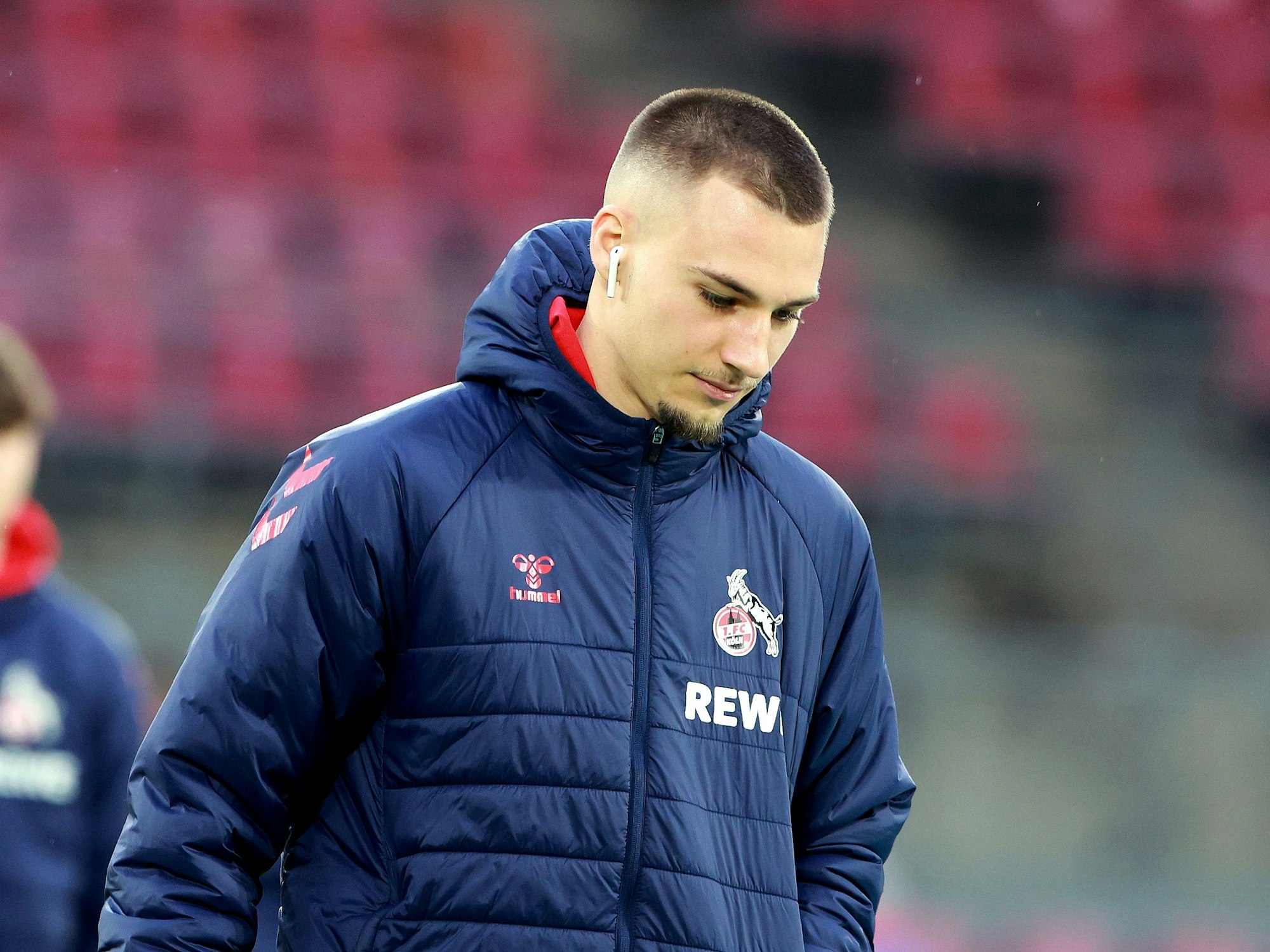 Tim Lemperle (1. FC Köln) geht in Trainingsjacke über das Spielfeld.