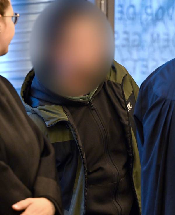 Der Angeklagte (Mitte) wartet am 21. Januar im Gerichtssaal auf den Beginn des Prozesses. Dem Angeklagten aus Solingen werden vier Straftaten vorgeworfen.