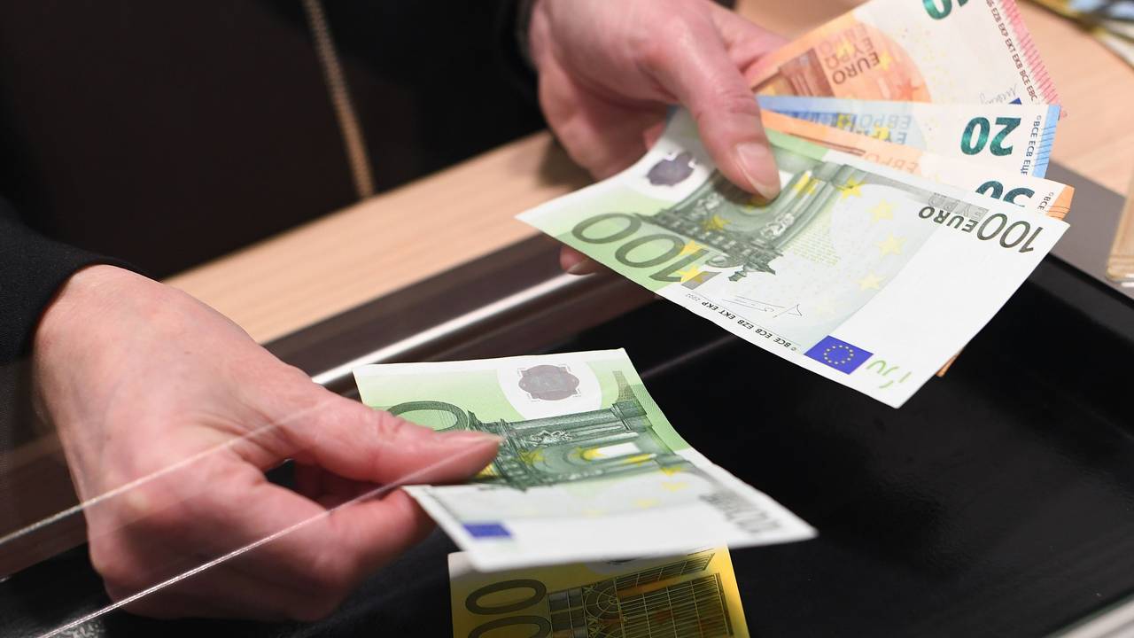 Eine Frau lässt sich in einer Bankfiliale am Schalter Bargeld auszahlen.(Symbolbild)