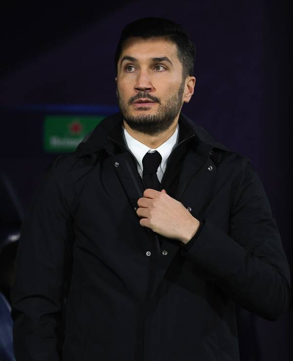 Dortmunds Trainer Nuri Sahin fasst im Stadion an seine Krawatte.