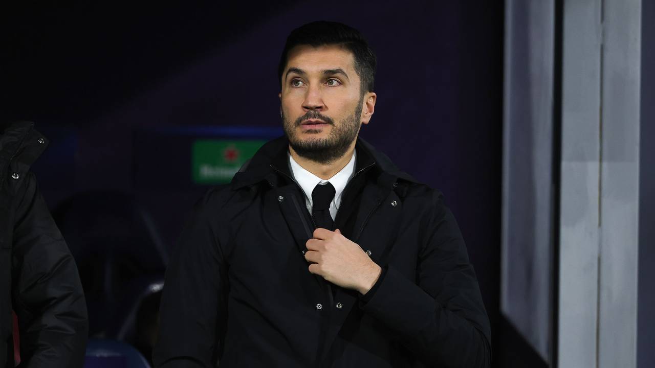 Dortmunds Trainer Nuri Sahin fasst im Stadion an seine Krawatte.