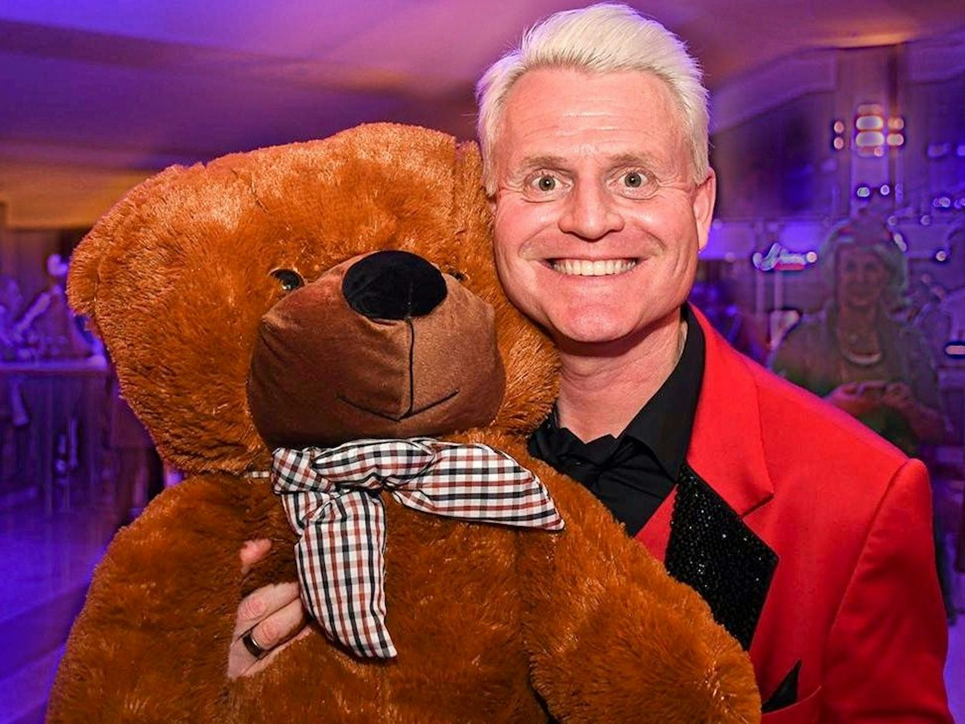 Guido Cantz hält einen Teddybär im Arm.