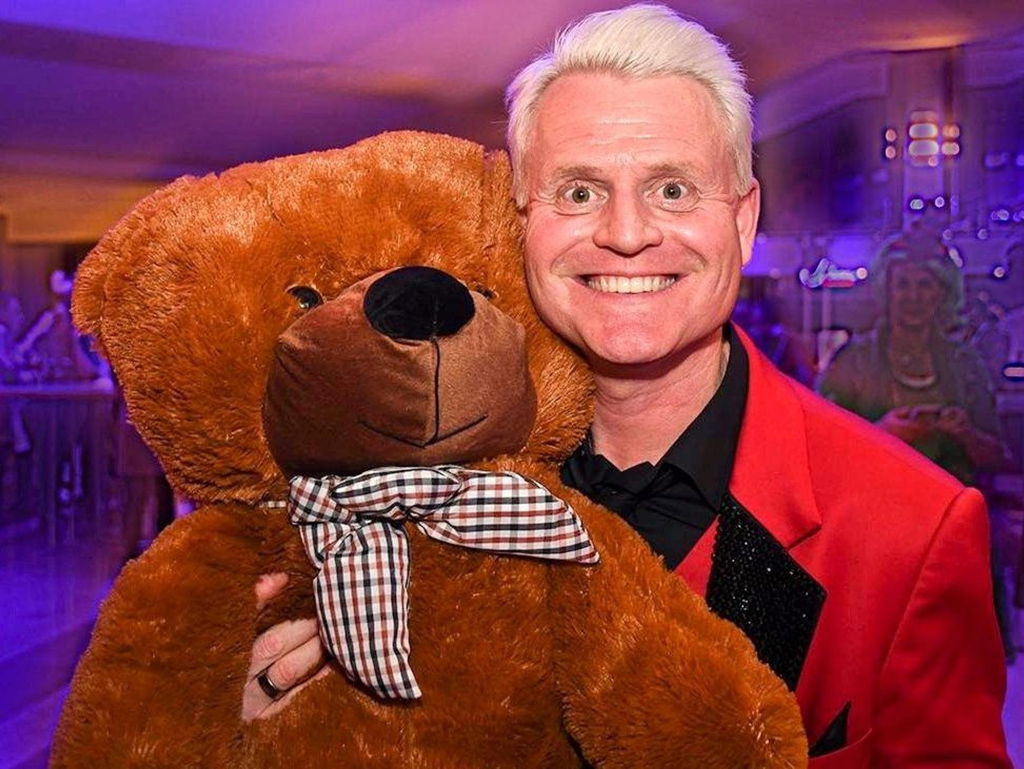 Guido Cantz hält einen Teddybär im Arm.