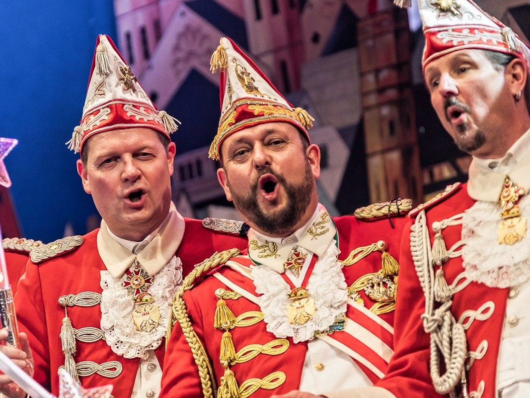 Der Vorstand der Roten Funken feiert auf der Bühne.