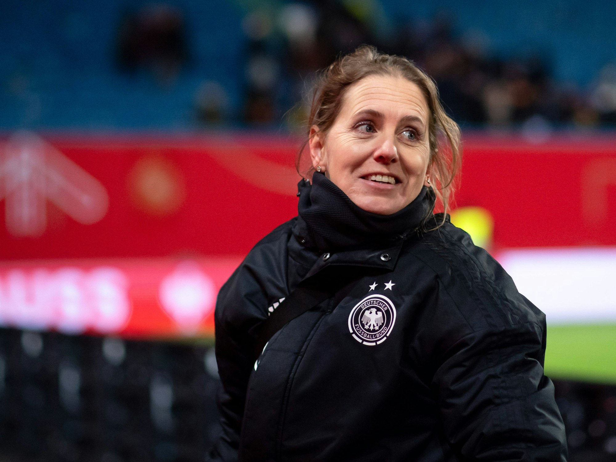 Britta Carlson in DFB-Winterjacke bei einem Länderspiel.