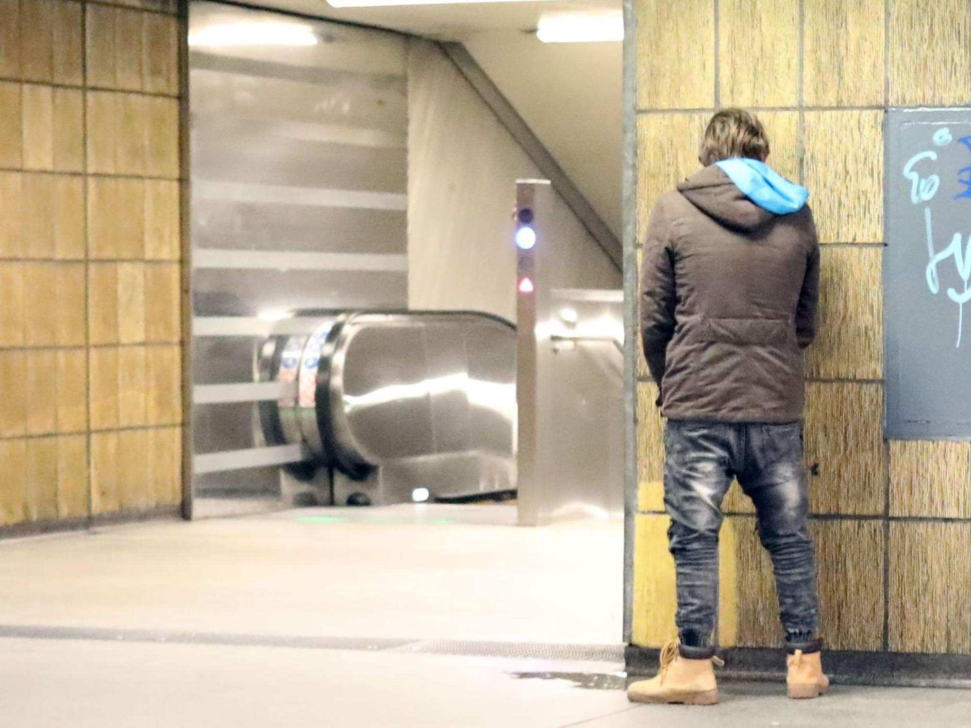 Ein Mann entleert sich in einer U-Bahn Haltestelle.