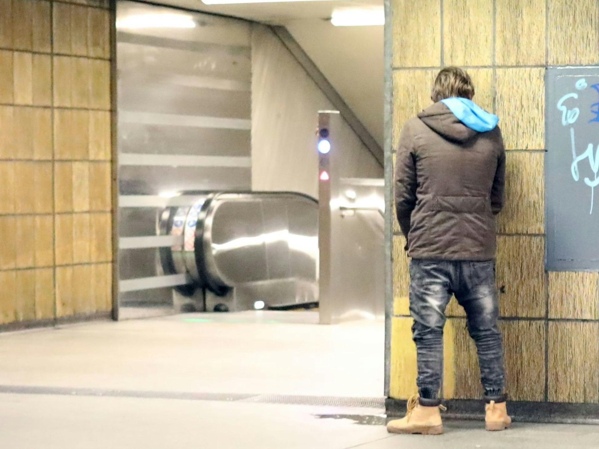 Ein Mann entleert sich in einer U-Bahn Haltestelle.