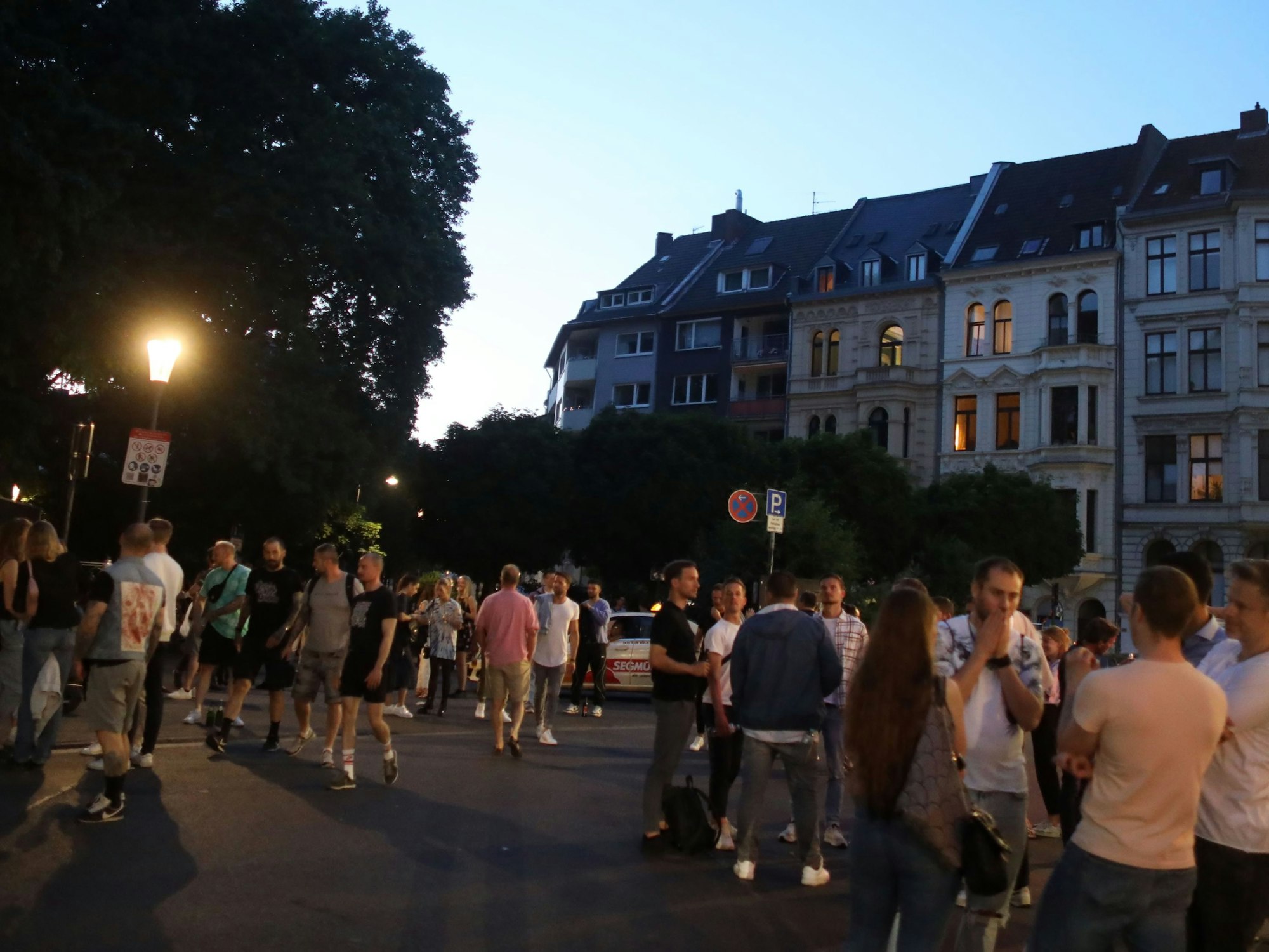 Viele Menschen stehen am Abend auf dem Brüsseler Platz in Köln und genießen den Abend.