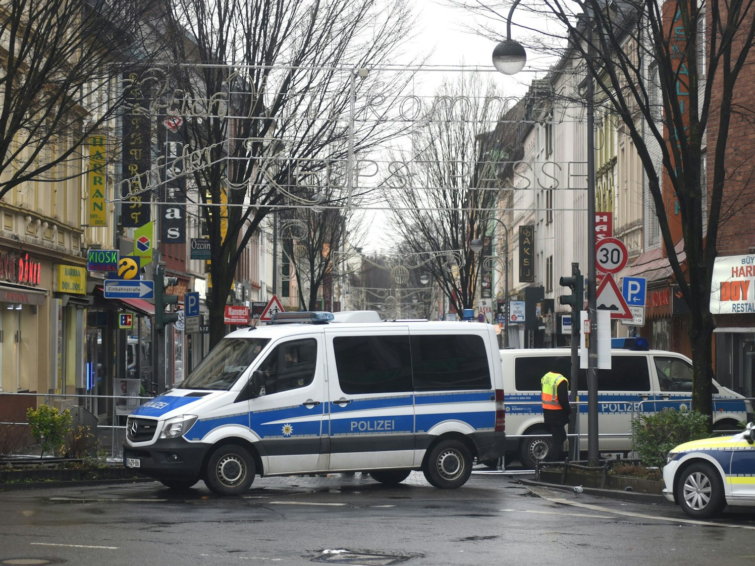 Ein Polizeiauto steht vor einem Straßeneingang.