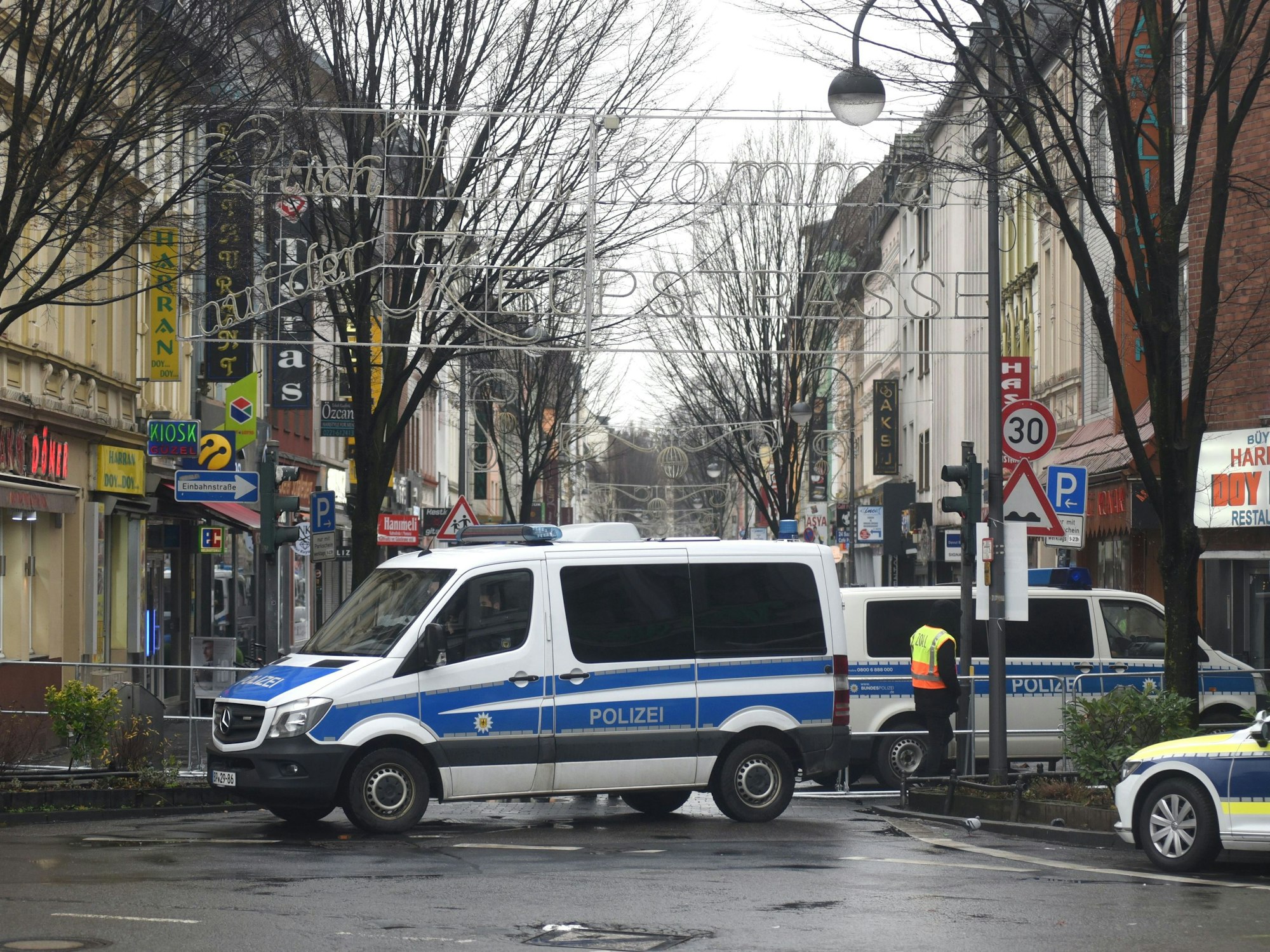 Ein Polizeiauto steht vor einem Straßeneingang.